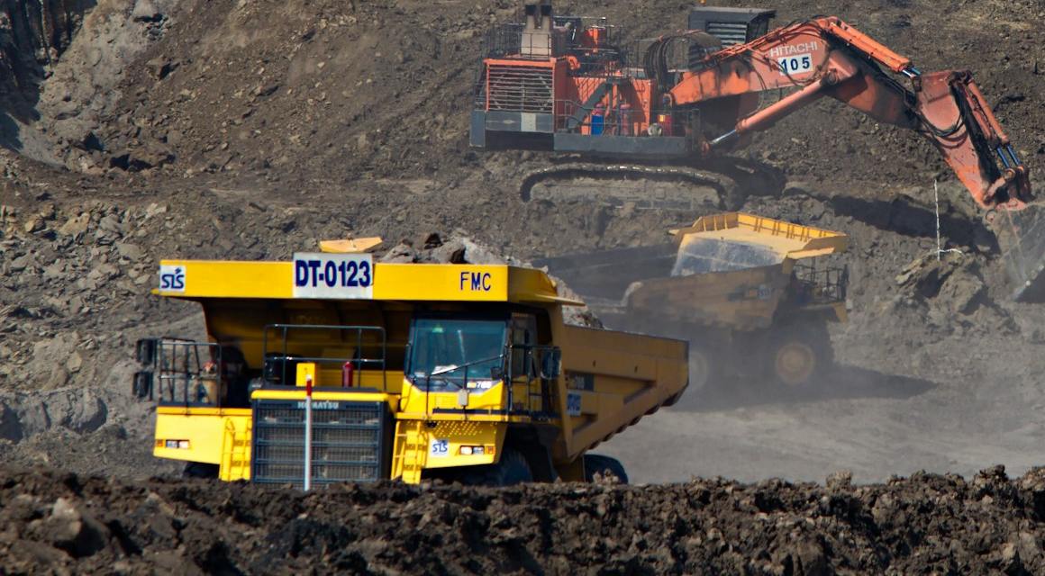 Haul trucks and excavators working an open-pit mine